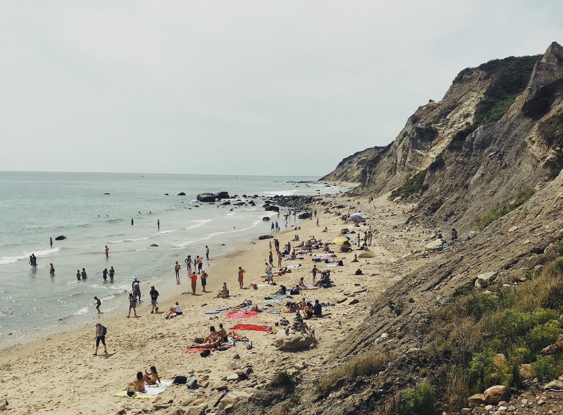 People on the beach at Mohegan Bluffs, New Shoreham, Block Island, Rhode Island, United States - one of the best dog friendly beaches in Rhode Island