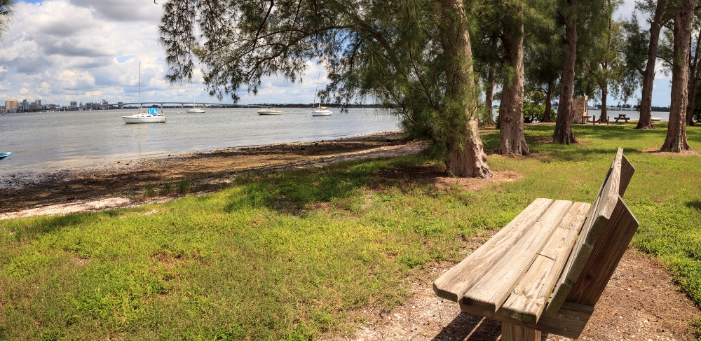 Bench view of boats at the Ken Thompson Park in Sarasota, Florida - one of the best dog friendly beaches in Sarasota